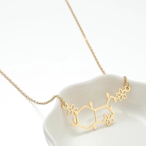Gouden ketting met chemische moleculaire structuur en kleine bloemendetails