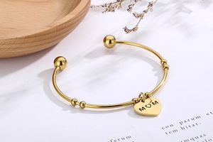 Vue détaillée du bracelet cœur en acier doré avec gravure MOM et décor floral