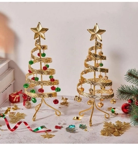 Close-up of golden metal spiral Christmas tree desktop decor with colorful bells