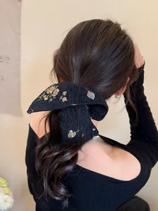 Close-up of a floral jacquard scrunchie styled on a ponytail in a vintage aesthetic