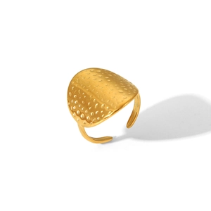 Close-up of golden adjustable stainless steel ring featuring irregular hammered texture