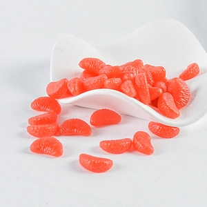 Macro detail of miniature PVC orange slices showing realistic fruit pulp texture on white tray