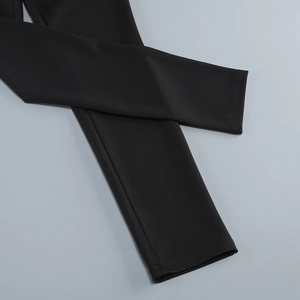 Detailed close-up of double-stitched hem on black high-waist jumpsuit leggings