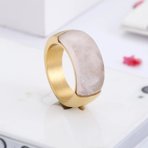 Detail of a brushed gold titanium ring featuring a large rectangular pink gemstone