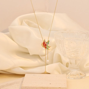 Nahaufnahme der goldenen Halskette mit farbigem Emaille-Schmetterling und Perlen