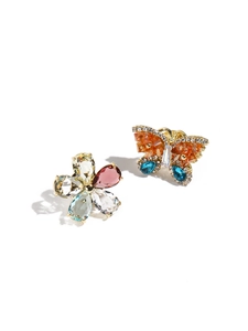 Detail of asymmetric butterfly and floral gold earrings with colorful rhinestones
