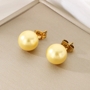 Macro detail of high-quality polished golden ball earrings with secure butterfly backs