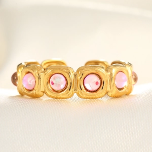 Macro detail of gold vintage ring with square frames and pink synthetic opal stones