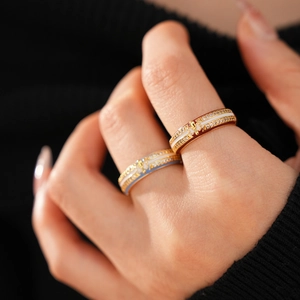 Detailed macro of 18k gold plated enamel rings with fleur-de-lis and zircon inlays