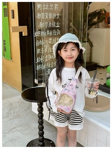 Girl wearing a pink crossbody bag with colorful star sequins and adjustable white strap