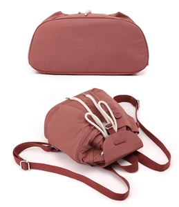 Detail view of brick red nylon mini backpack with drawstring closure and adjustable straps