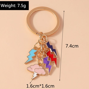 Détails d'un porte-clés doré avec des pendentifs émaillés en forme de nuage et d'éclairs