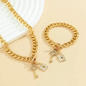 Detail of gold Cuban chain set with rhinestone-paved key and lock pendants and OT buckle