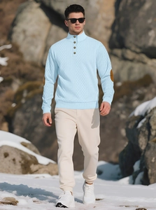 Detail of light blue waffle knit sweater with stand collar and brown elbow patches