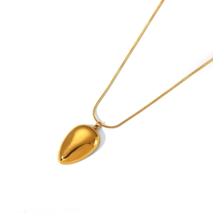 Macro detail of 18K gold plated teardrop pendant with a polished mirror finish on snake chain