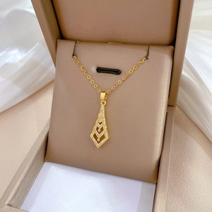 Detailed view of luxury gold titanium steel chevron pendant with white zircons on a jewelry box