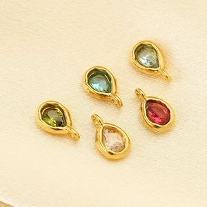 Detailed view of colorful teardrop stone pendants with golden stainless steel frames