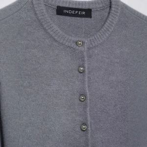 Cardigan grigio in maglia con scollo rotondo e bottoni metallici sferici in vista frontale