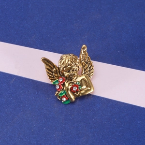 Macro detail of retro gold angel brooch with enamel flowers and sparkling crystal accents