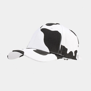 Detail of adjustable silver metal buckle and cow print pattern on cotton baseball cap