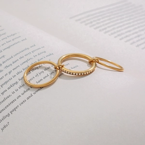 Detailed view of triple-layered gold stainless steel ring with micro-pave crystals on book