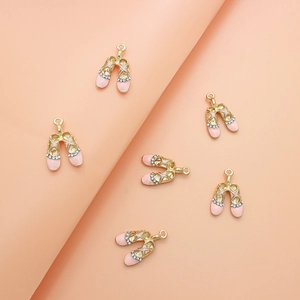 Detail of pink ballet shoe charms with gold trim and small rhinestones for DIY jewelry