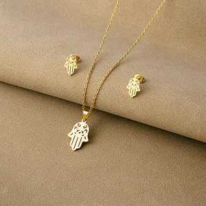 Detail of gold-plated Hamsa Hand pendant necklace and matching stud earrings set
