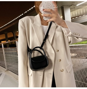 Fille portant un mini sac bandoulière noir en similicuir avec un blazer beige en extérieur