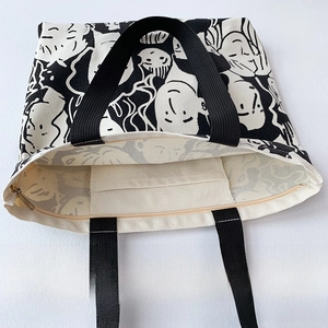 Detail of canvas tote featuring top zipper closure and internal storage pocket