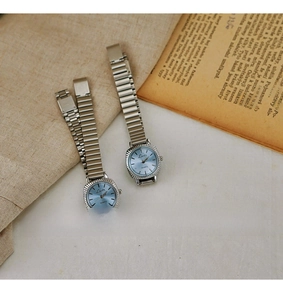 Detail of vintage ladies quartz watches with silver metal straps and blue sunray dials
