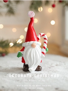 Gnome de Noël peint à la main en résine sur neige avec des lumières bokeh chaleureuses