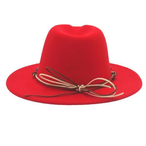 Détail d'un fedora en feutre de laine rouge avec ruban tissé et nœud décoratif