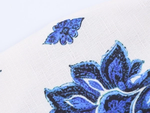 Vista macro de estampado floral azul en tela de algodón blanco con textura tejida