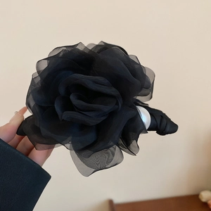 Vue détaillée de la pince à cheveux rose en tissu noir avec accent de perle élégante