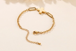 Detail of gold-plated cross bracelet with lobster clasp and adjustable extension chain