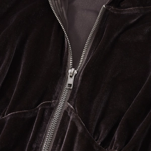 Detail von dunkelbraunem Samtstoff und silbernem Metallreißverschluss am Kapuzenpullover
