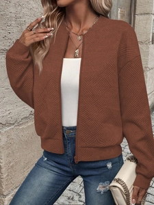 Detail of brown quilted zip-up jacket with textured diamond pattern for women
