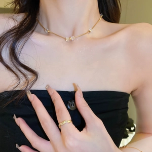 Golden sugar cube necklace and wave diamond ring set on female model for luxury look