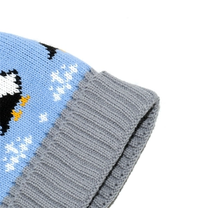 Detailed close-up of blue penguin jacquard knit and grey ribbed cuff on child's hat