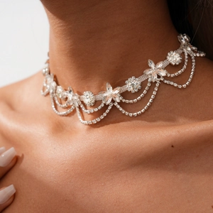 Detail of luxury choker with crystal flowers and elegant silver tiered chains on model