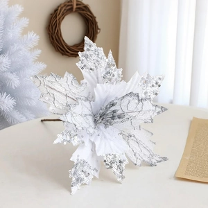 Close-up of a white velvet Christmas poinsettia with silver sequins and glitter details