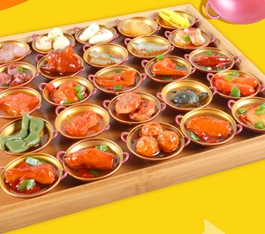 Makroansicht detaillierter Miniatur-China-Food-Modelle in Goldtöpfen auf Holztablett