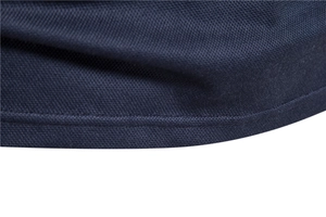 Macro shot of navy blue polo fabric showing detailed knitting texture and precise stitching