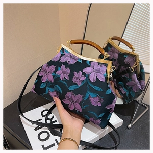 Detailed embroidery of purple flowers on a Chinese style handbag with a wooden handle