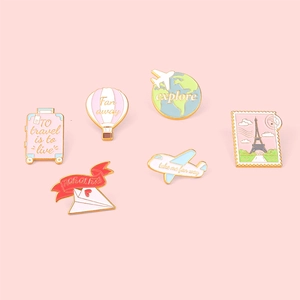 Pink travel enamel pins set featuring airplane luggage and hot air balloon motifs