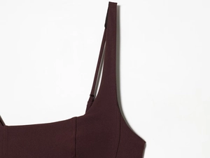 Close-up of elegant deep reddish-brown sleeveless dress with thin straps and smooth fabric