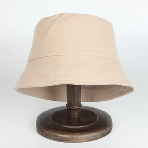 Détail du chapeau bob en coton kaki avec coutures fines sur un support en bois