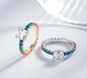Macro detail of Asscher cut square diamond ring with rainbow colored pave set gemstones