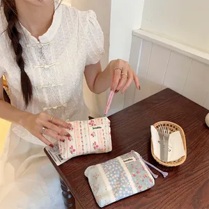 Detail of floral canvas pouches with Sozakka label and woven wristlet for storage