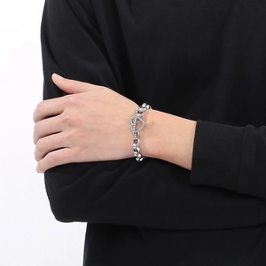 Détail d'un bracelet à maillons en forme de cœur argenté avec fermoir OT sur un mannequin